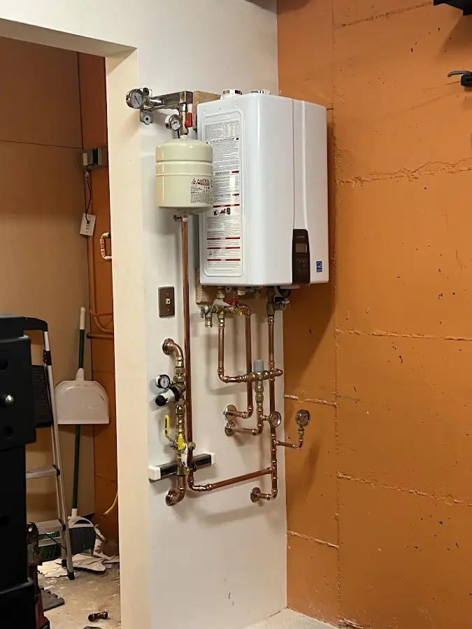 Plumbing technician inspecting water heater connections in Asbury Lake